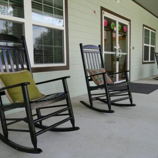 A cozy porch with rocking chairs and windows.