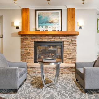 A cozy living room with a stone fireplace and modern furniture.