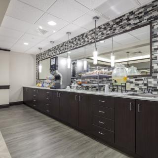A modern kitchen interior with sleek cabinetry and a large mirror.