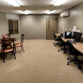 A small office space with computer workstations and a table with chairs.