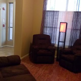A cozy living room with plush chairs and a standing lamp.