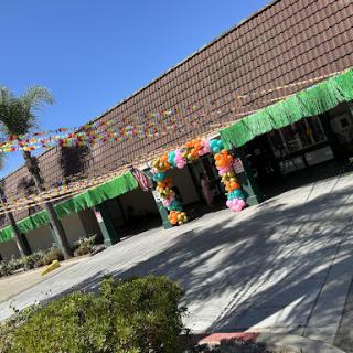 A beautifully decorated building entrance, adorned with colorful flowers and greenery, ready for a festive event.