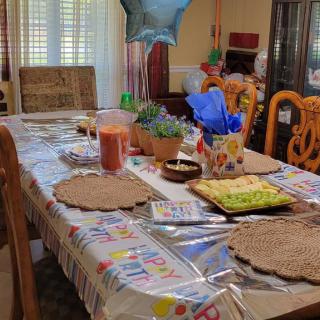 A festive table set for a birthday celebration with balloons and decorations.