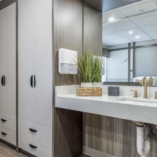 A modern bathroom featuring stylish cabinetry, a sleek sink, and decorative plants.