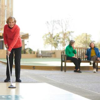 Seniors enjoying a game of golf in a park setting.