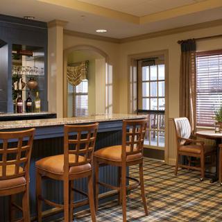 Cozy bar interior with wooden chairs and a patterned carpet.