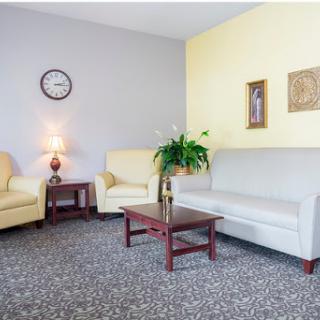 A cozy living room setup featuring a sofa, armchairs, and a coffee table, adorned with decorative elements.