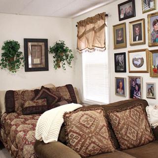 A cozy living room with patterned couches, wall art, and family photos.