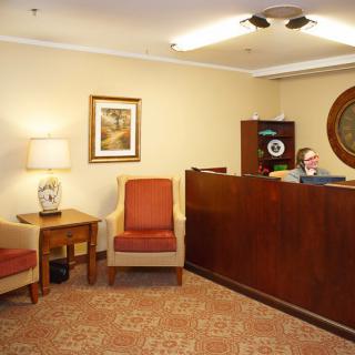A welcoming office reception area with a wooden desk, comfortable chairs, and stylish decor.
