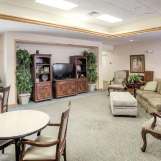 Spacious, well-lit living room with elegant furniture and a central entertainment unit.