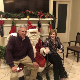 A cheerful holiday gathering with Santa Claus by the fireplace.