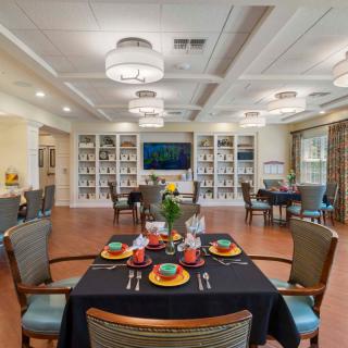 A well-decorated dining area with set tables, bookshelves, and elegant lighting.