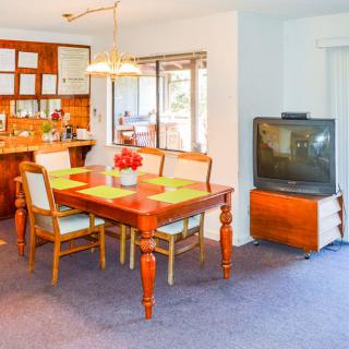 A cozy dining area with a wooden table and chairs, adjacent to a vintage television set.