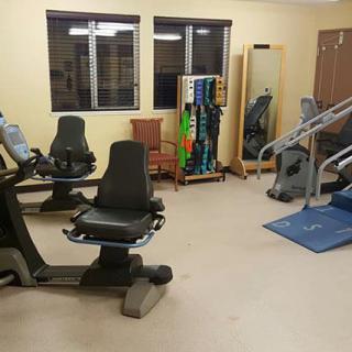A gym room equipped with various exercise machines and fitness equipment.