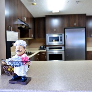 A modern kitchen with a playful chef figurine on the counter.