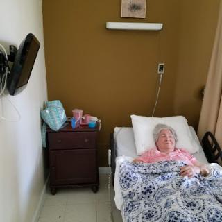 A patient resting in a hospital room, surrounded by care essentials.