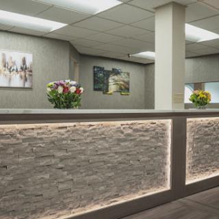 A modern reception area featuring elegant floral arrangements and contemporary artwork on the walls.