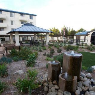 A well-maintained garden with a fountain and gazebo in an apartment complex courtyard.