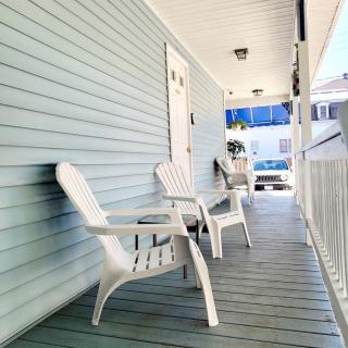 A cozy porch with white chairs offers a perfect spot for relaxation.