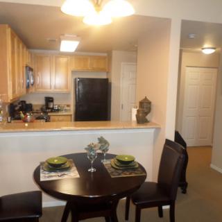 A cozy apartment kitchen with a small dining area featuring a round table and two chairs.