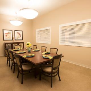 A spacious dining room featuring a large wooden table, elegant chairs, and tasteful decor, perfect for gatherings.