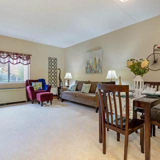 A cozy living room with a dining area, featuring comfortable furniture and elegant decor.