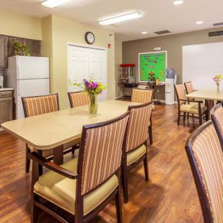 A cozy dining area with tables, chairs, and a kitchen space.