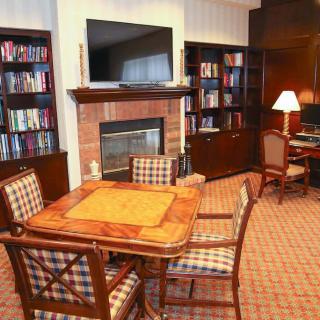 Cozy living room with a bookshelf, fireplace, and a seating area.