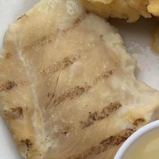 Grilled fish fillet served on a plate.