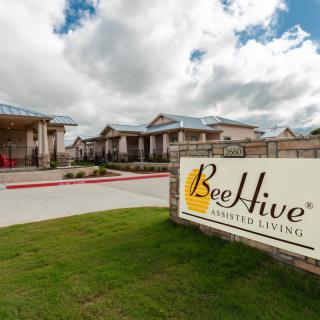 BeeHive Homes assisted living facility with a sign and buildings in the background.