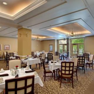An elegant restaurant dining room with neatly arranged tables and chairs.