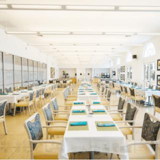 A spacious dining area with neatly arranged tables and chairs, ready for guests.