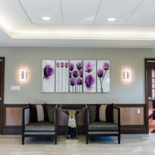 A serene and modern waiting area featuring elegant floral artwork and comfortable seating.