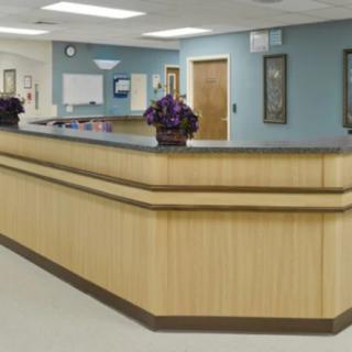A hospital reception area with a wooden desk and clean interior design.