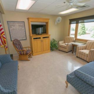 A cozy waiting room with comfortable seating and a television.