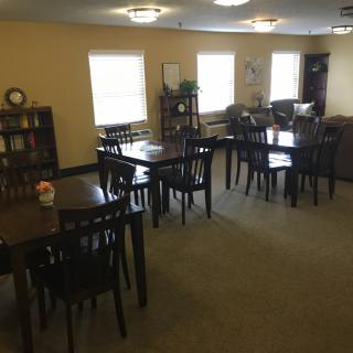 A quiet dining area with multiple wooden tables and chairs arranged neatly.
