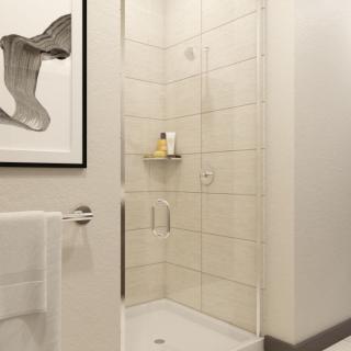A modern and minimalist bathroom with a glass shower enclosure and tiled walls.