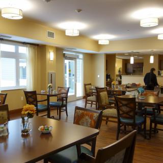 A well-lit dining area with neatly arranged tables and chairs.