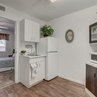 A minimalist kitchen with a refrigerator, cabinetry, and decorative elements.
