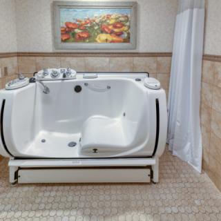 A modern bathroom featuring a high-tech bathtub with tile flooring and decorative artwork.