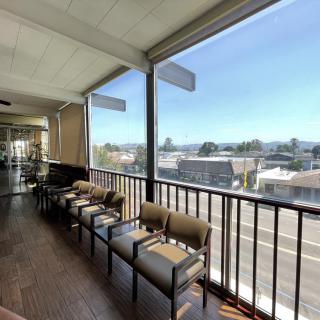 A well-lit office waiting area with chairs overlooking a cityscape through large windows.
