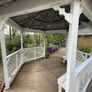 An inviting gazebo nestled in a lush green setting, perfect for relaxation.