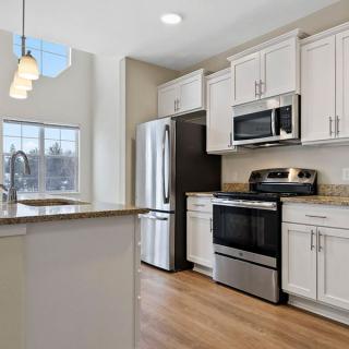 A modern kitchen with stainless steel appliances and white cabinets.