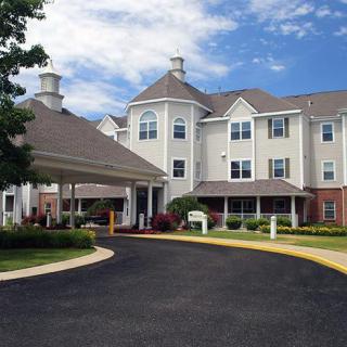 A well-maintained residential building with landscaped surroundings under a clear blue sky.