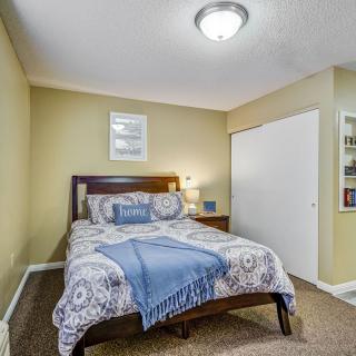 A cozy bedroom with a neatly made bed, warm lighting, and tasteful decor.