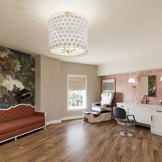 Modern salon interior with a stylish chandelier, hairdressing station, and wooden flooring.