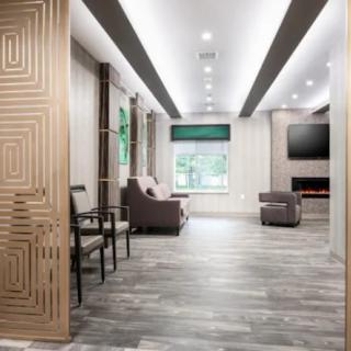 A modern living room with stylish decor and comfortable seating, featuring a large window for natural light.