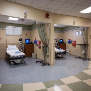 A view of patient rooms in a hospital, equipped with beds and monitoring equipment.