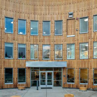 Modern building with a wooden facade and multiple windows.