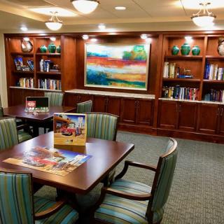 A cozy library area with bookshelves, comfortable seating, and colorful artwork.